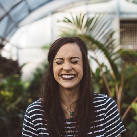 woman smiling while standing in garden