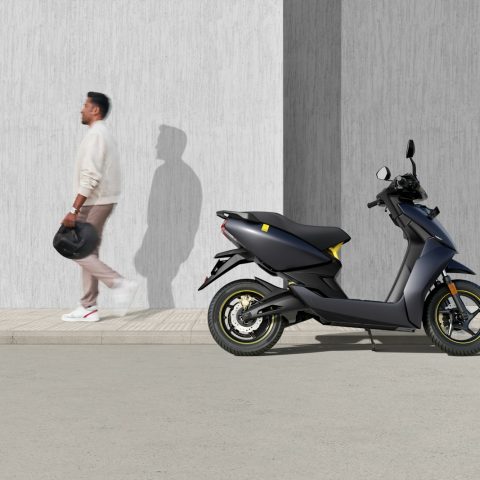 man in white t-shirt and black shorts riding blue motor scooter