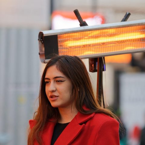 Staande terrasverwarmer op een verlicht buitenterras tijdens een koele avond