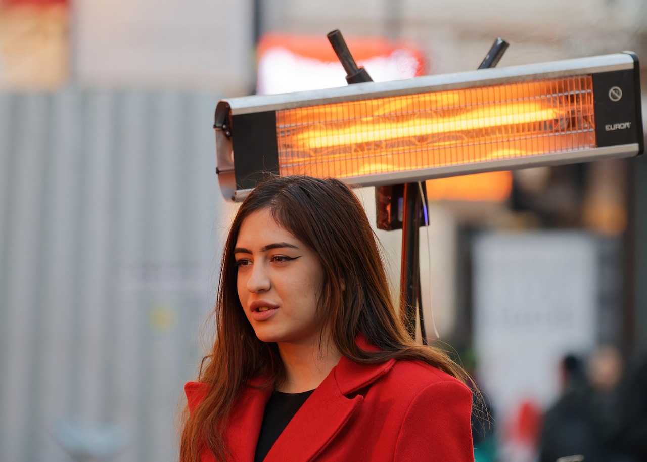 Staande terrasverwarmer op een verlicht buitenterras tijdens een koele avond