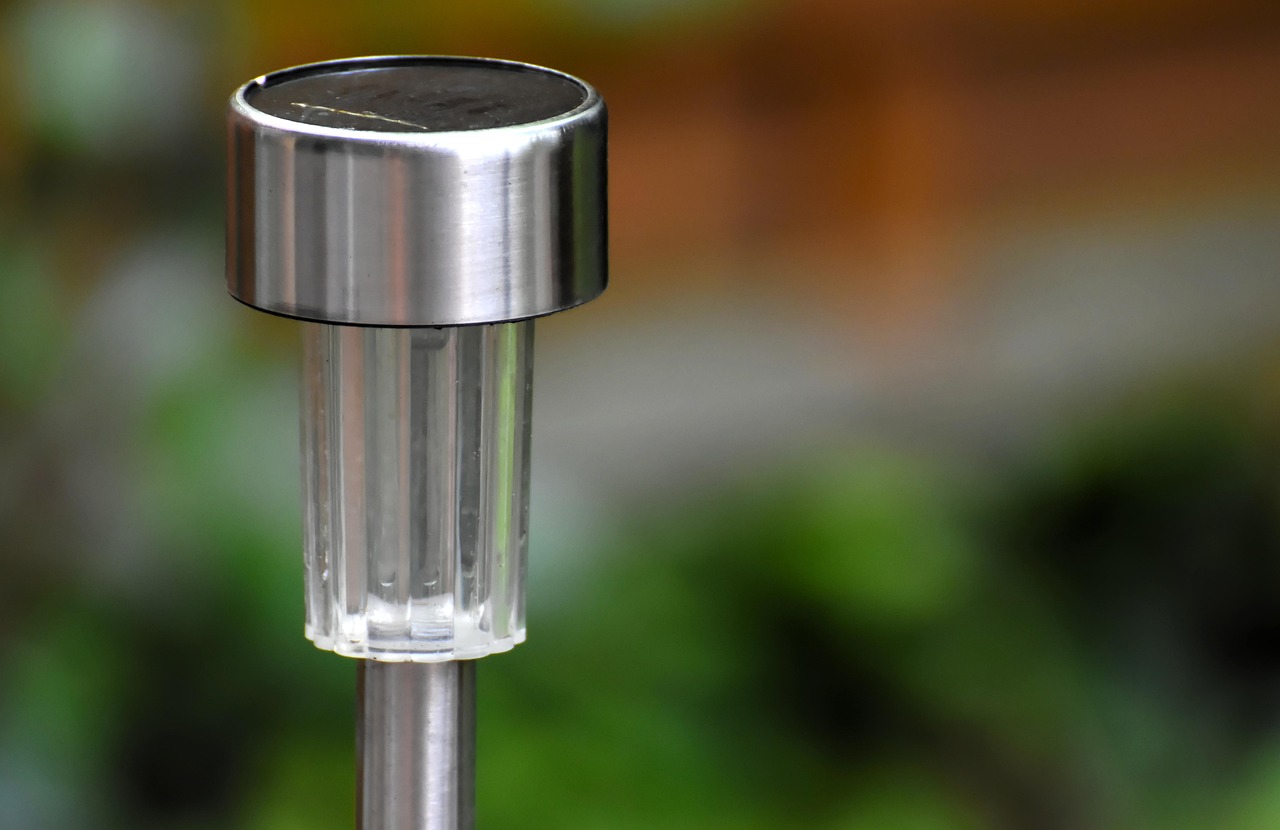 Zonnelampjes langs een tuinpad in een groene tuin bij schemering
