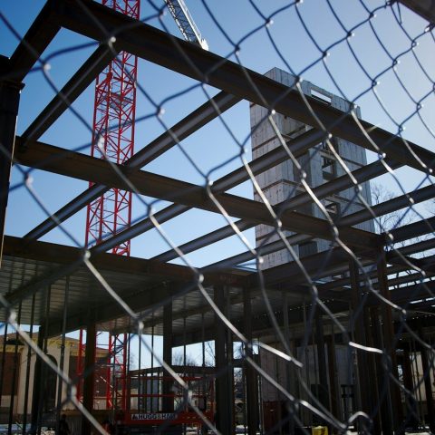 a construction site is seen through a chain link fence