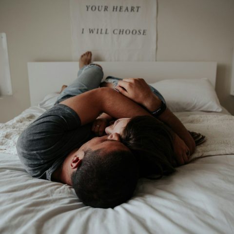 A man and woman cuddling together in bed