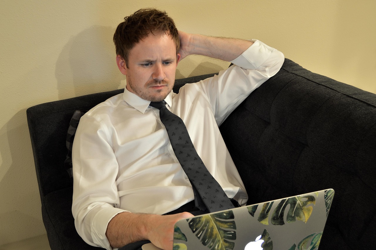 Man achter laptop thuis die internetsnelheid test